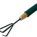 Close-up of a Marksman Hand Cultivator With Foam Handle featuring a wooden design and green rubber grip. This essential gardening tool comes with a small metal head equipped with three curved prongs for soil loosening and cultivation. The hand cultivator is positioned diagonally on a white background.