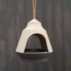 The Earthy Natural/Anthracite Bamboo 2-tone Hanging Bird Feeder is vegan-friendly, crafted from bamboo with a sleek design and an anthracite dish. It hangs elegantly from a rope against rustic wooden planks.