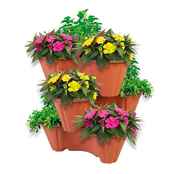 The Strawberry Planter Terracotta Stackable Plant Pot, a three-tiered planter with a terracotta hue, showcases vibrant yellow and pink flowers amidst lush green foliage. Its durable plastic construction and stackable design make it perfect for creating a compact and space-efficient display of blooming plants.