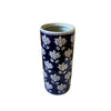 The Blue With White Flower Umbrella Stand features a tall, cylindrical ceramic design with a dark blue background and white floral patterns—ideal as a stylish hallway umbrella holder.