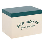 The Seed Packet Storage Box is a beige garden storage container with a green lid, featuring "SEED PACKETS" in bold green letters on the front and "grow your own" in smaller, cursive text below it. Inside, you'll find labeled dividers to keep everything organized.
