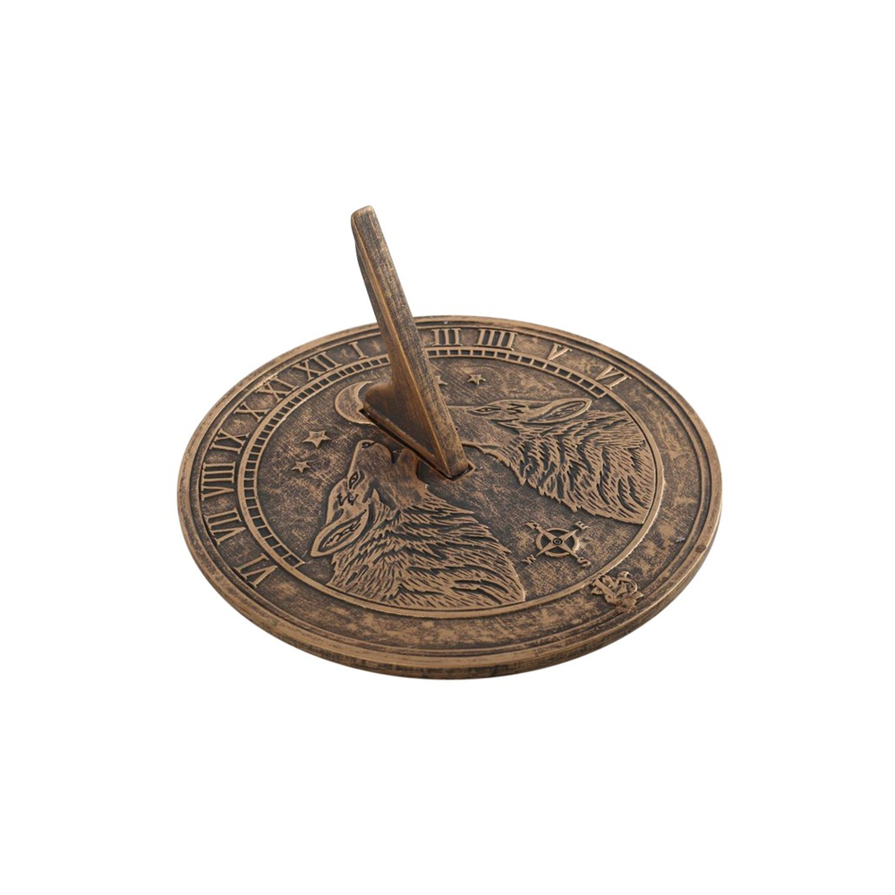 The Howling Wolves Terracotta Sundial by Lisa Parker showcases an elaborate and rustic design with two embossed wolf heads and Roman numerals encircling its edge. Its upright gnomon artfully casts a shadow to tell the time, making this sundial both enchanting and practical.