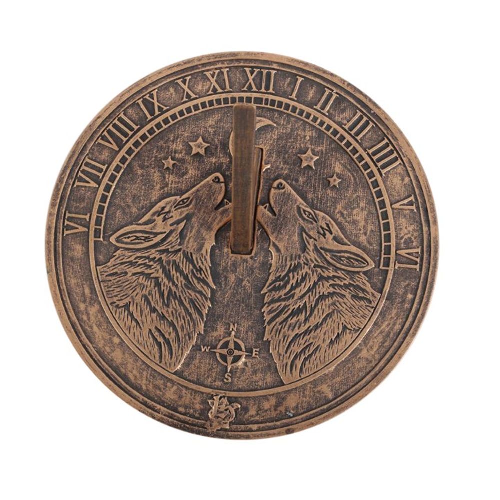 A terracotta sundial named "Howling Wolves" by Lisa Parker, featuring engraved wolves with Roman numerals for the hours. Adorned with stars and a compass rose, the gnomon directs towards the center. It showcases an antique bronze finish.