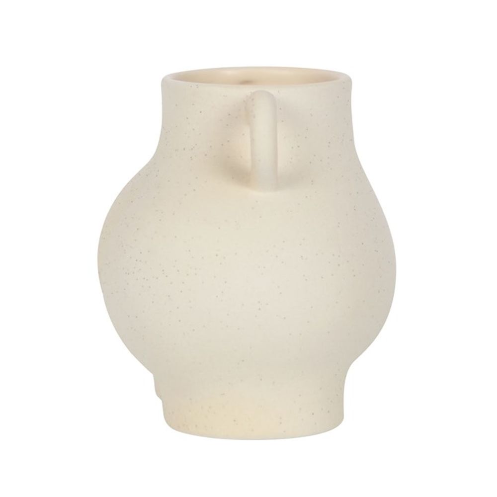 The Cream Speckle Bum Plant Pot boasts a quirky design with its beige ceramic finish, rounded speckled surface, and single handle near the top. Its off-center wide base enhances its minimalist charm, making it an ideal piece for unique home decor against a white backdrop.
