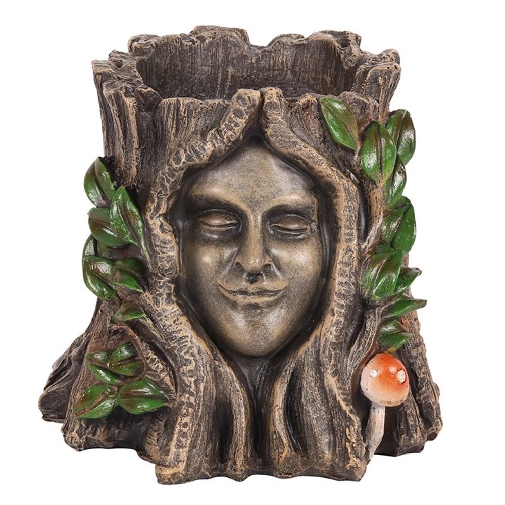 This sculpted planter, "The Green Goddess Plant Pot," resembles a tree trunk with a serene human face, featuring green leaves and a red-and-white mushroom for a whimsical, nature-inspired garden touch. Perfect for housing your beloved Green Goddess plant.