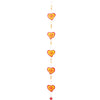 The Red/Yellow String Of Hearts is a vertical hanging decoration with five red hearts bordered in yellow, spaced along a string and accented with tiny orange beads. This ethically sourced piece serves as a delightful suncatcher, casting warm hues across your room when placed in your window.