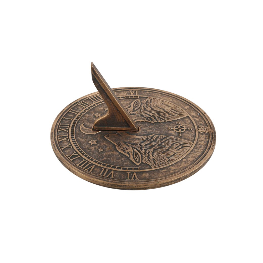 The Howling Wolves Terracotta Sundial, created by Lisa Parker, showcases a bronze triangular gnomon adorned with intricate wolf engravings. Around its edge, Roman numerals elegantly mark the hours. This exquisite piece rests gracefully on a white background, capturing the timeless charm of nature and art combined.