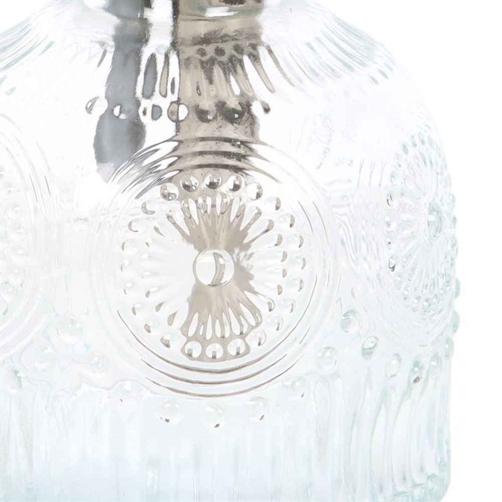 A close-up of a vintage glass lampshade with intricate circular patterns, much like the detailed texture reflecting in the Small Patterned Glass Plant Mister.