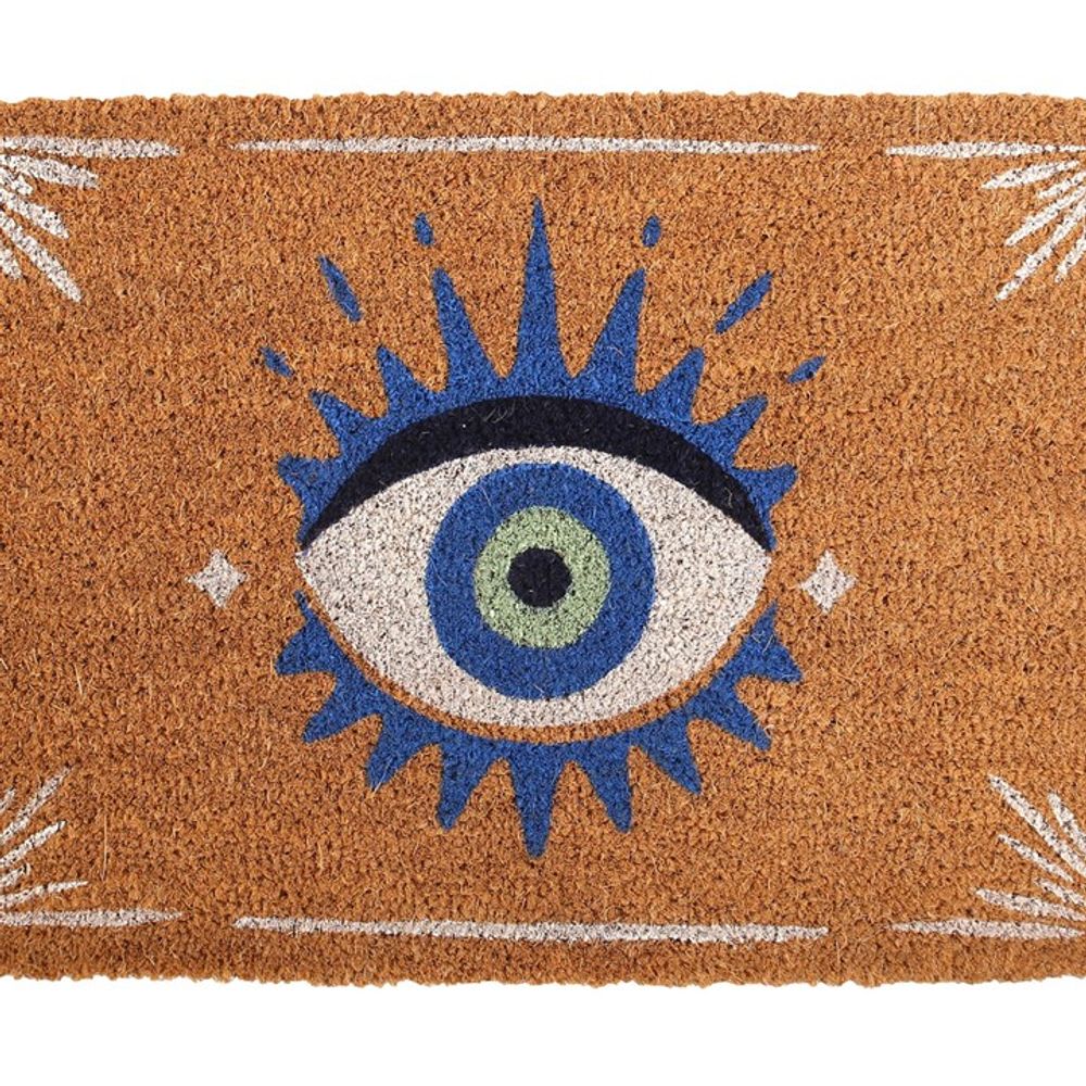 The Natural All Seeing Eye Doormat features a whimsical design with a large blue eye, a green and blue pupil in the center, and is surrounded by blue and white geometric accents on a rich brown background.
