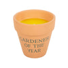 The Gardener of the Year Citronella Candle features vibrant yellow citronella wax in a rustic terracotta pot with elegant script, offering a lovely contrast for any ceramic plant pot display.