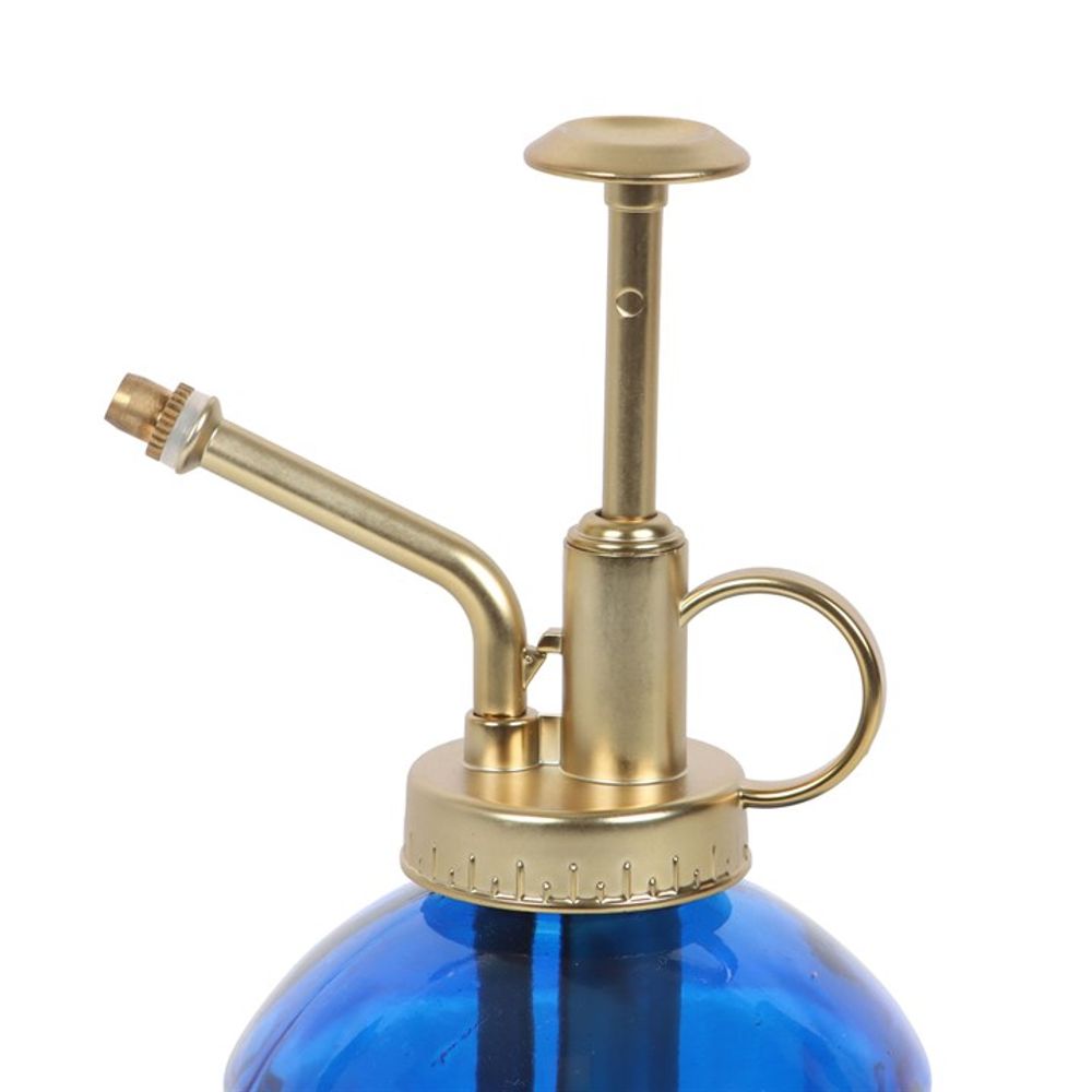 The Small Blue Glass Plant Mister, a favorite among indoor garden lovers, showcases a gold-colored metal pump and nozzle. Its sophisticated design is enhanced with a ring handle, making it an ideal choice for any plant caretaker looking to add a hint of vintage charm.
