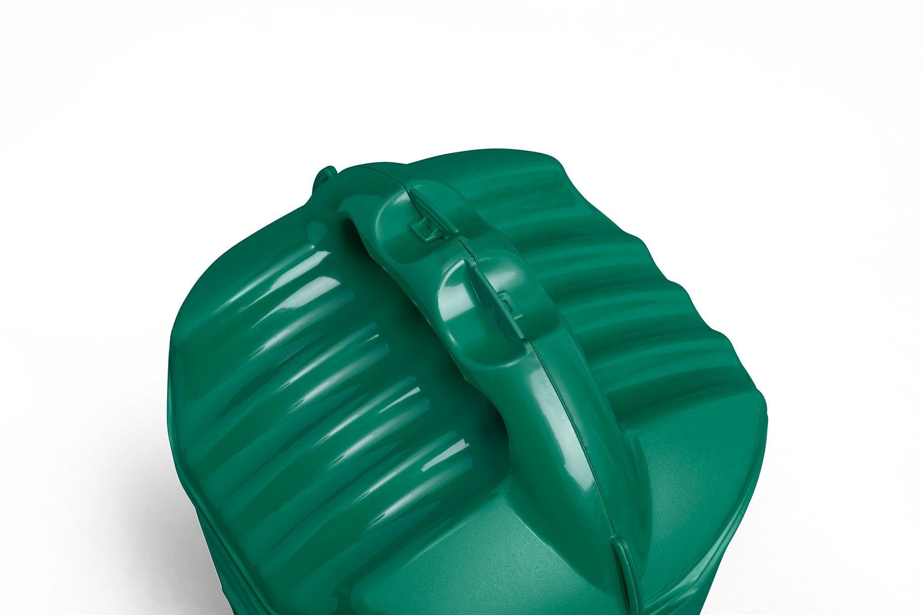 The Multipurpose Garden Spreader, Twist & Shake Action is a green plastic container with a textured lid and a built-in handle. It features a series of raised ridges and a central, curved handle for easy gripping. With its 5kg capacity, this versatile spreader has multiple uses. The spreader is set against a white background.