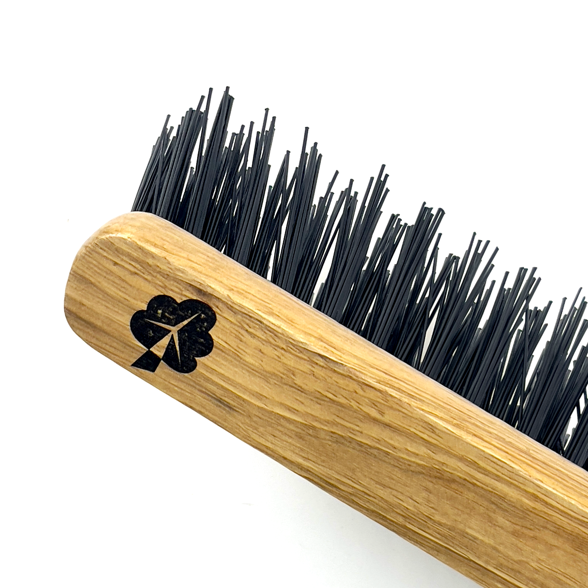 The Hand Brush with Hard Bristles from etree features a wooden handle with a natural finish and tough black bristles. It is accented by a minimalistic black tree logo on the handle near the bristles, and is showcased against a plain white background.
