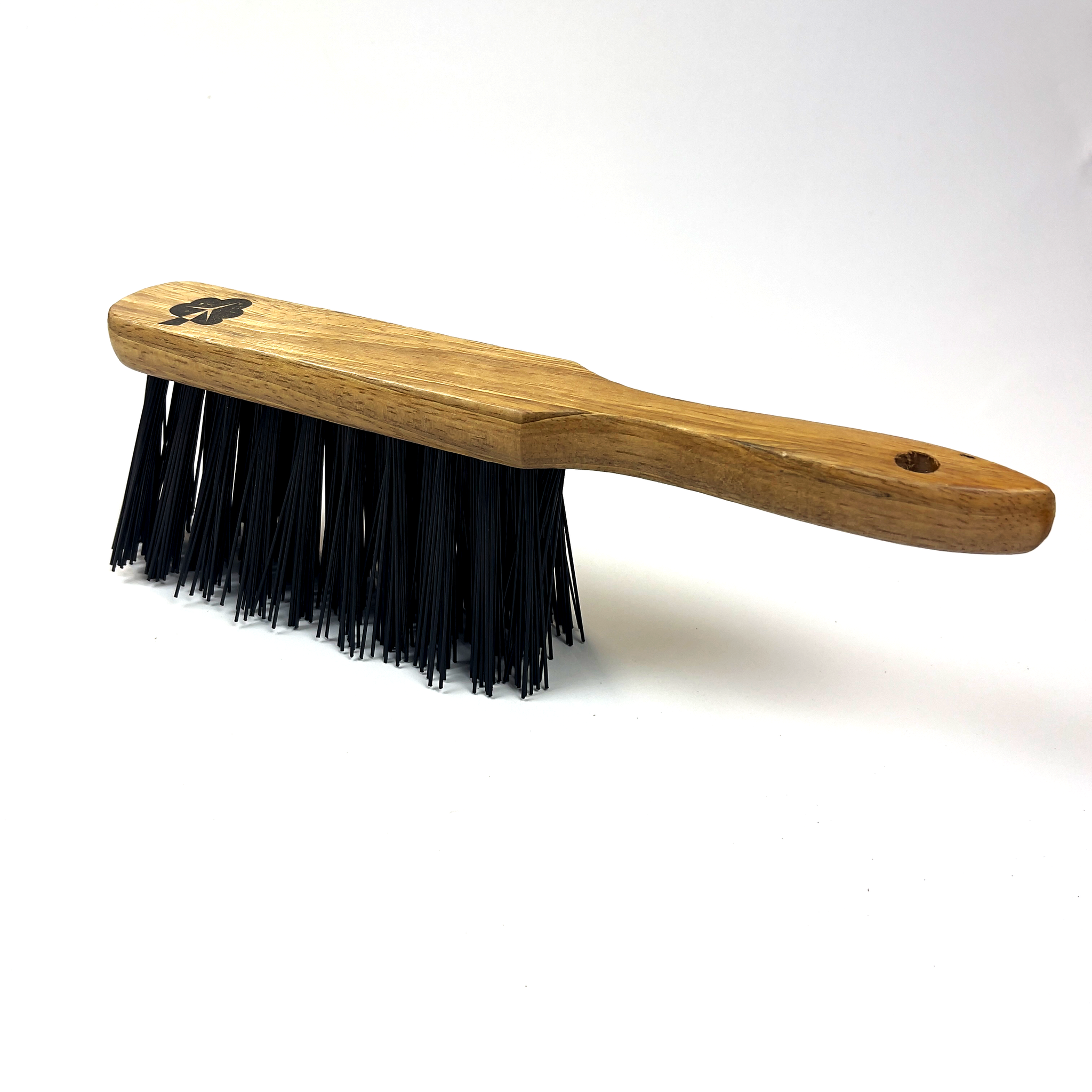 The Hand Brush with Hard Bristles by etree boasts a compact wooden handle and dense, black bristles organized in a rectangular layout. Its firm bristles make it ideal for heavy-duty cleaning tasks. The handle, which is pictured on a white background, has a hole at one end for easy hanging.