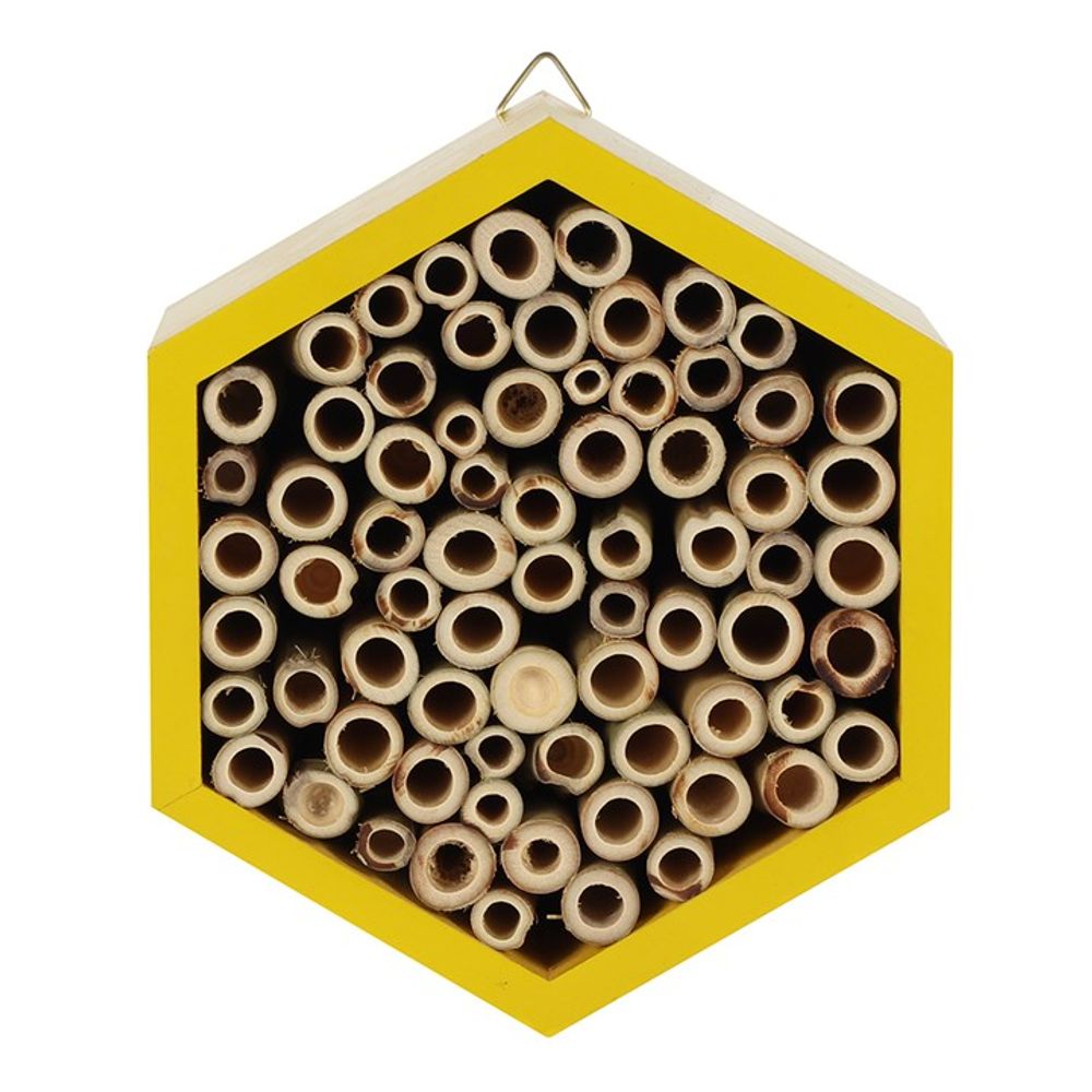 The Wooden Bee House is a hexagonal bee hotel featuring a yellow wooden frame and filled with various-sized bamboo tubes, creating an inviting garden retreat for solitary pollinators.