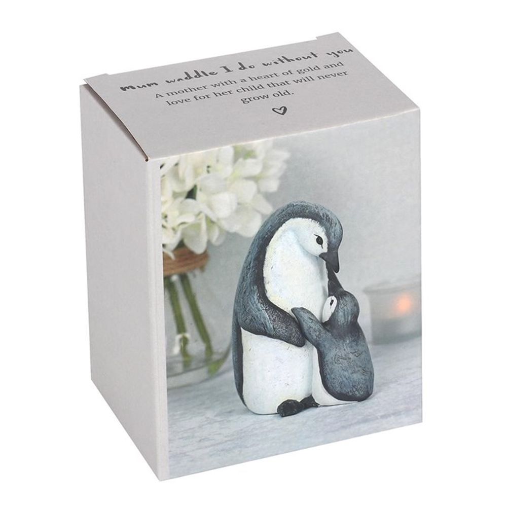 The Mum Waddle I Do Without You Penguin Ornament, presented in a cardboard box, features a touching scene of a parent and chick penguin embracing. Accompanied by a candle and white flowers, it serves as a heartfelt gift. The ornament bears the text "mum, what would I do without you," honoring the special bond between mother and child.