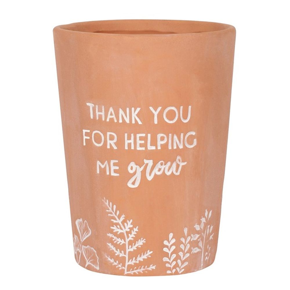 The Thank You For Helping Me Grow Terracotta Plant Pot features white text saying "Thank you for helping me grow" and charming white leaf and plant illustrations along the bottom.