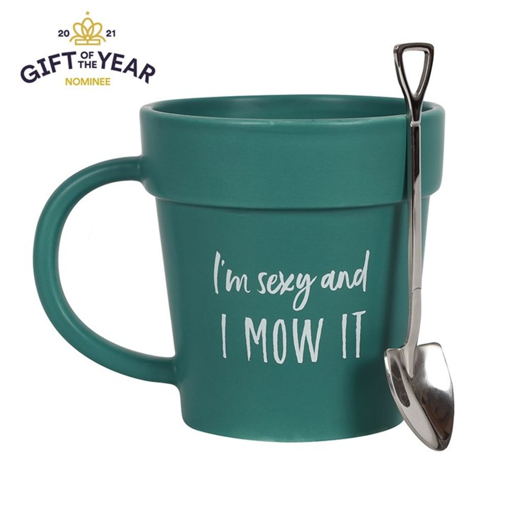 Introducing the Sexy and I Mow It Pot Mug and Shovel Spoon: a green ceramic terracotta mug uniquely designed to resemble a flower pot, emblazoned with the playful text "I'm sexy and I MOW IT" on the front. A charming small shovel-shaped teaspoon dangles from its handle. Recognized as a "Gift of the Year 2021 Nominee," this delightful mug brings both whimsy and practicality to your tea or coffee time.