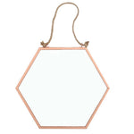 The Small Geometric Mirror, featuring a hexagonal shape with a copper-colored frame, is suspended by a rope knotted at both ends and attached to the top corners. Ideal for modern home decor, it creates a striking contrast against a plain white background and adds style to any space.