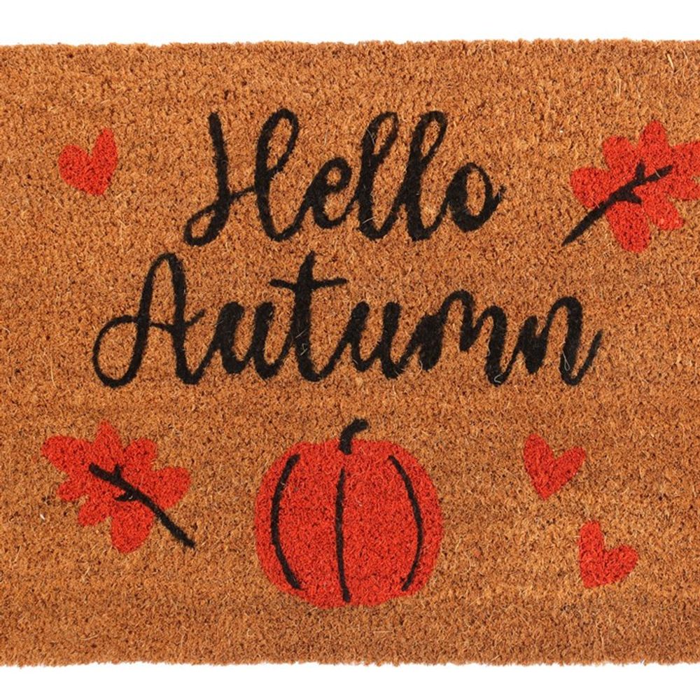 The Natural Hello Autumn Doormat features the text "Hello Autumn" written in black script, with a background adorned with red leaves, hearts, and a central illustration of an orange pumpkin.