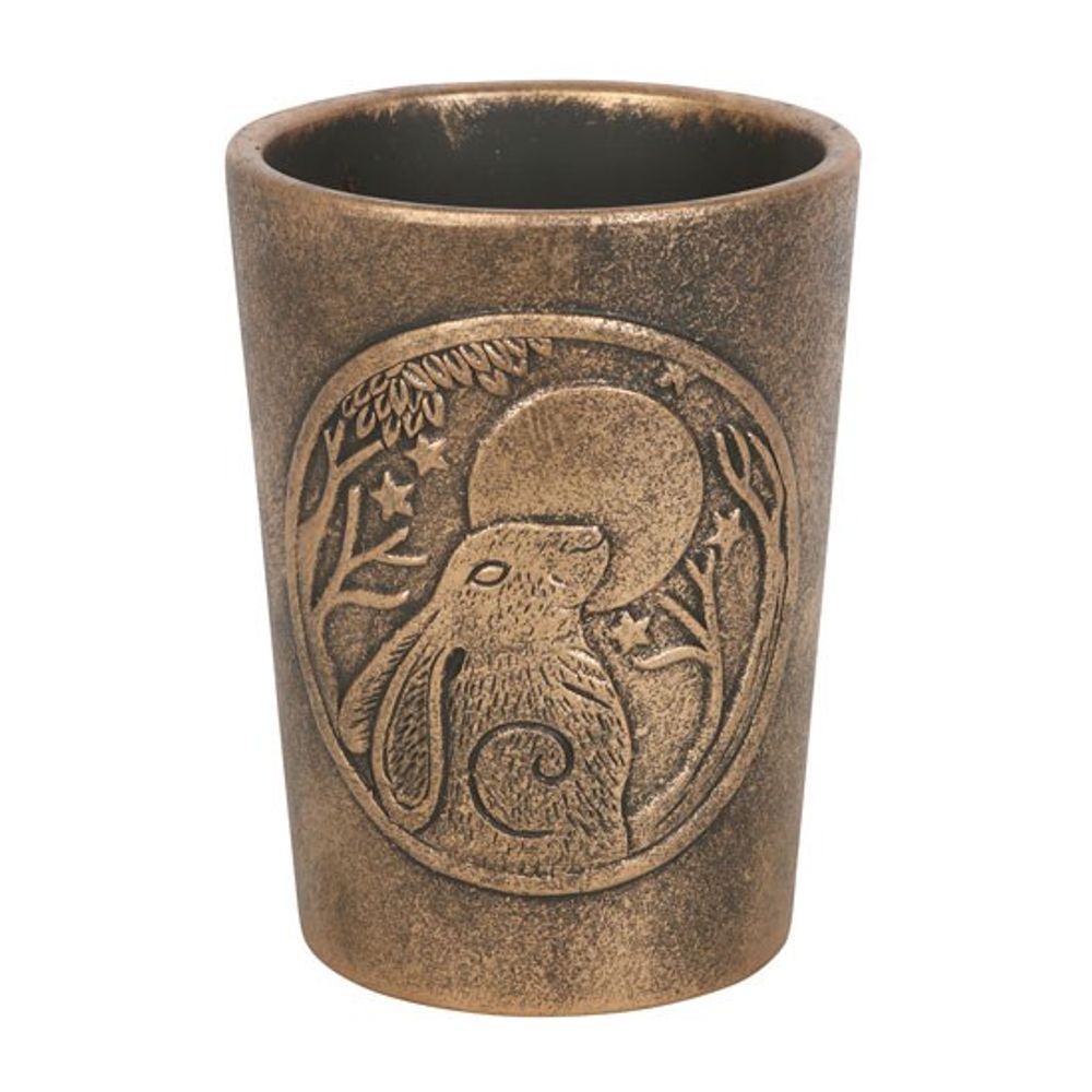 The Moon Gazing Hare Bronze Terracotta Plant Pot by Lisa Parker features a rustic bronze finish with an engraved design of a hare sitting amid trees and foliage, under the light of a large moon. Its intricate detailing affords it a vintage, artisanal appearance.