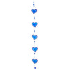 The Purple & Blue String Of Hearts suncatcher showcases a vertical arrangement of blue heart-shaped ornaments outlined in a deeper shade of blue. Ethically sourced beads are placed between the hearts, making it an eye-catching addition to window decor against a white background.