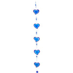 The Purple & Blue String Of Hearts suncatcher showcases a vertical arrangement of blue heart-shaped ornaments outlined in a deeper shade of blue. Ethically sourced beads are placed between the hearts, making it an eye-catching addition to window decor against a white background.