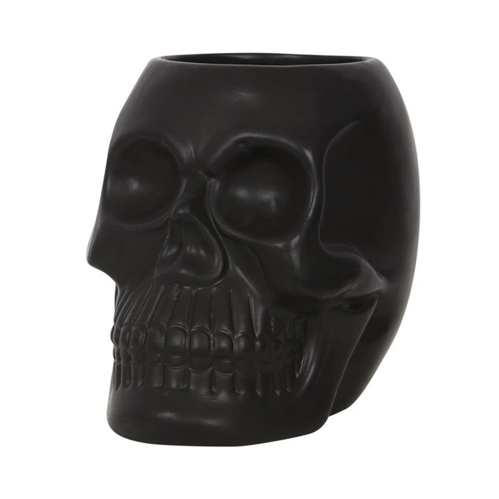 Introducing the Black Skull Plant Pot, a black ceramic mug intricately shaped like a skull. This unique piece showcases detailed eye sockets, nose cavity, and teeth to enhance its skull-like appearance. Perfect for adding a spooky touch as a house plant pot for those who love unique decor.
