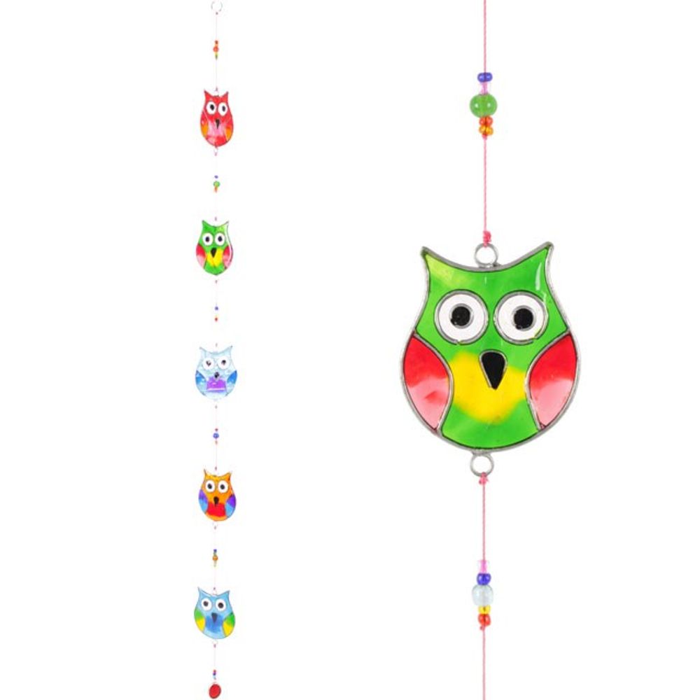 Introducing the "String Of Multi Owls," a vibrant suncatcher that features six small owl decorations aligned vertically, each in bright and varied colors with multicolored beads interspersed. Ethically sourced, the collection's largest owl is centrally positioned, showcasing a radiant blend of red, green, and yellow hues.