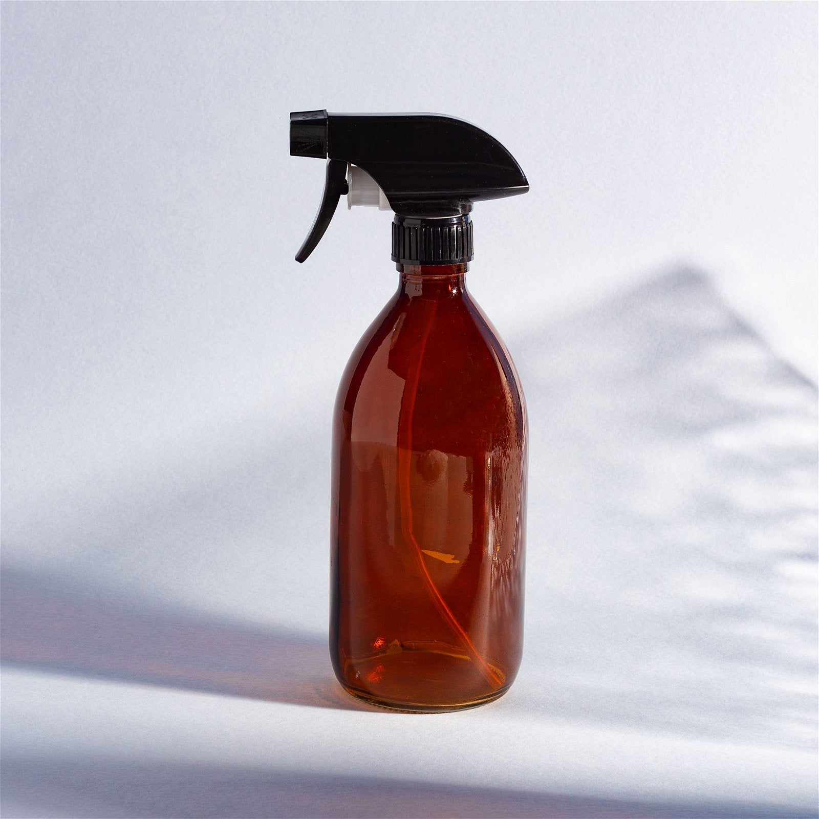 An amber coloured spray bottle shown on a table.