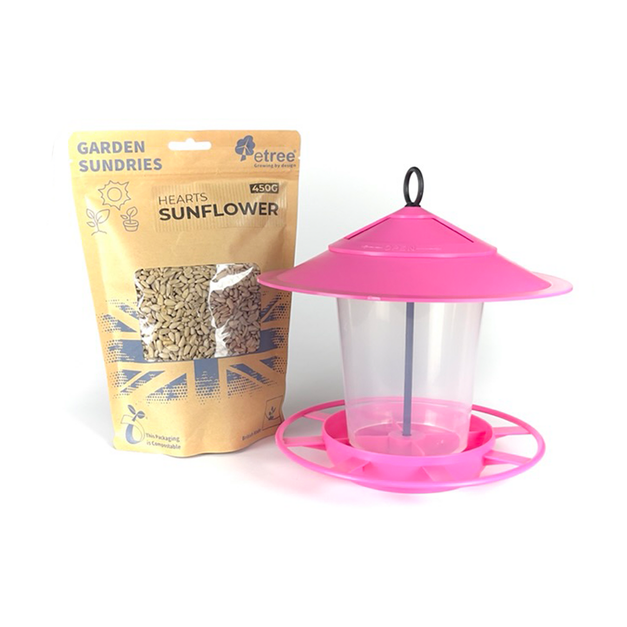 A pink Pre Filled Hanging Lantern Bird Feeder Gift Set, complete with a dome and tray, is placed next to a brown paper bag of 450g Sunflower Hearts Wild Bird Seed labeled "Garden Sundries." The feeder, featuring an easy-clean hook at the top for hanging, complements the bag’s clear window showcasing the seeds inside.