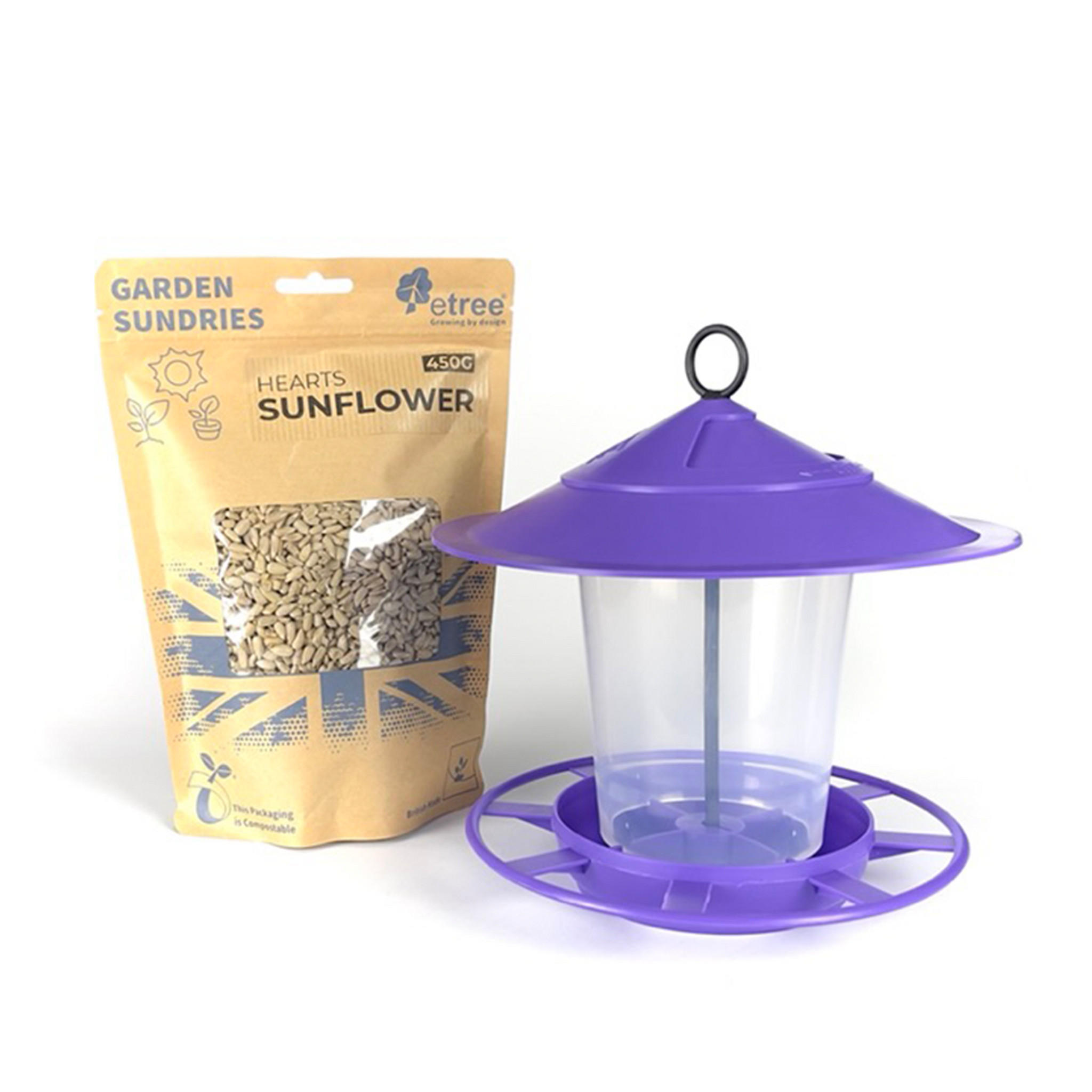 A Pre Filled Hanging Lantern Bird Feeder Gift Set & Sunflower Hearts Wild Bird Seed (450g), featuring a purple top and base, is positioned next to a brown package labeled "Garden Sundries" and "Hearts Sunflower 450g." The package has a clear window displaying sunflower hearts wild bird seed and is adorned with illustrations of sunflowers and recycling symbols.