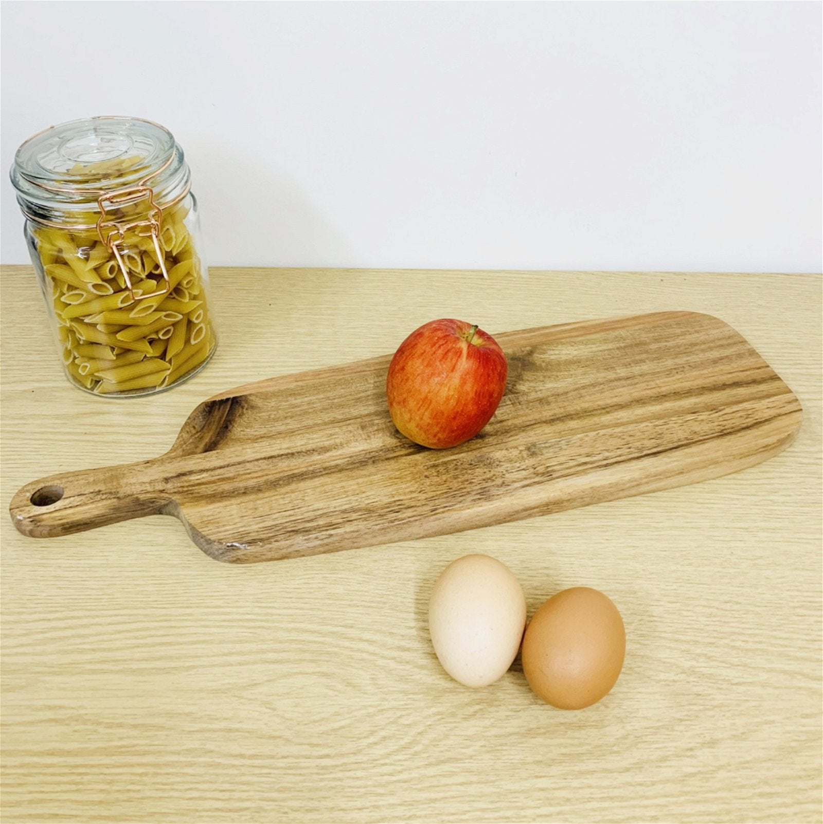 A wooden serving board shown with fruit and vegetables