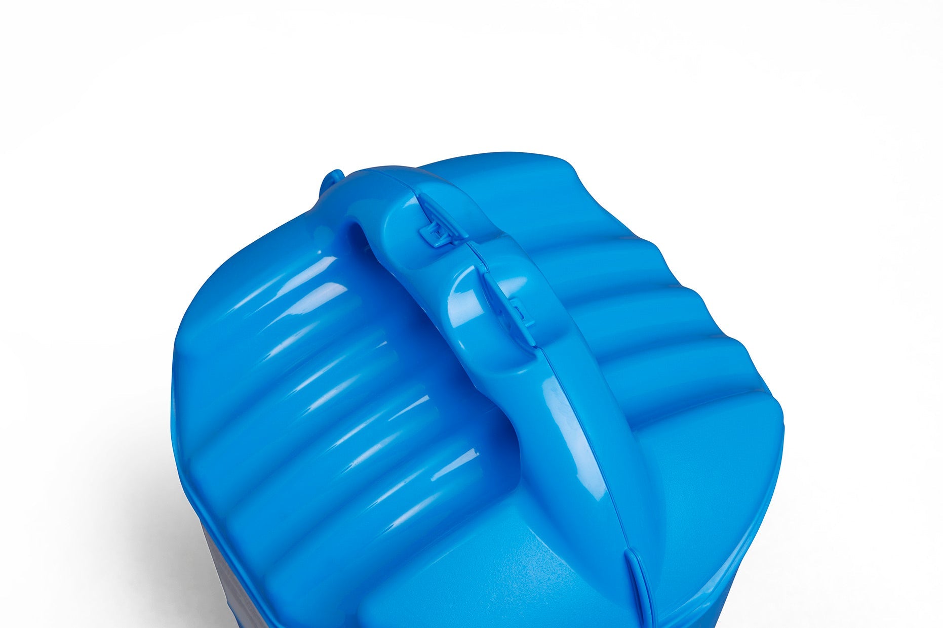 A close-up view of a bright blue plastic Winter Plastic Twist & Shake Salt Spreader, featuring a 5KG capacity, with ridges and a curved handle on its lid. The background is a plain white surface.