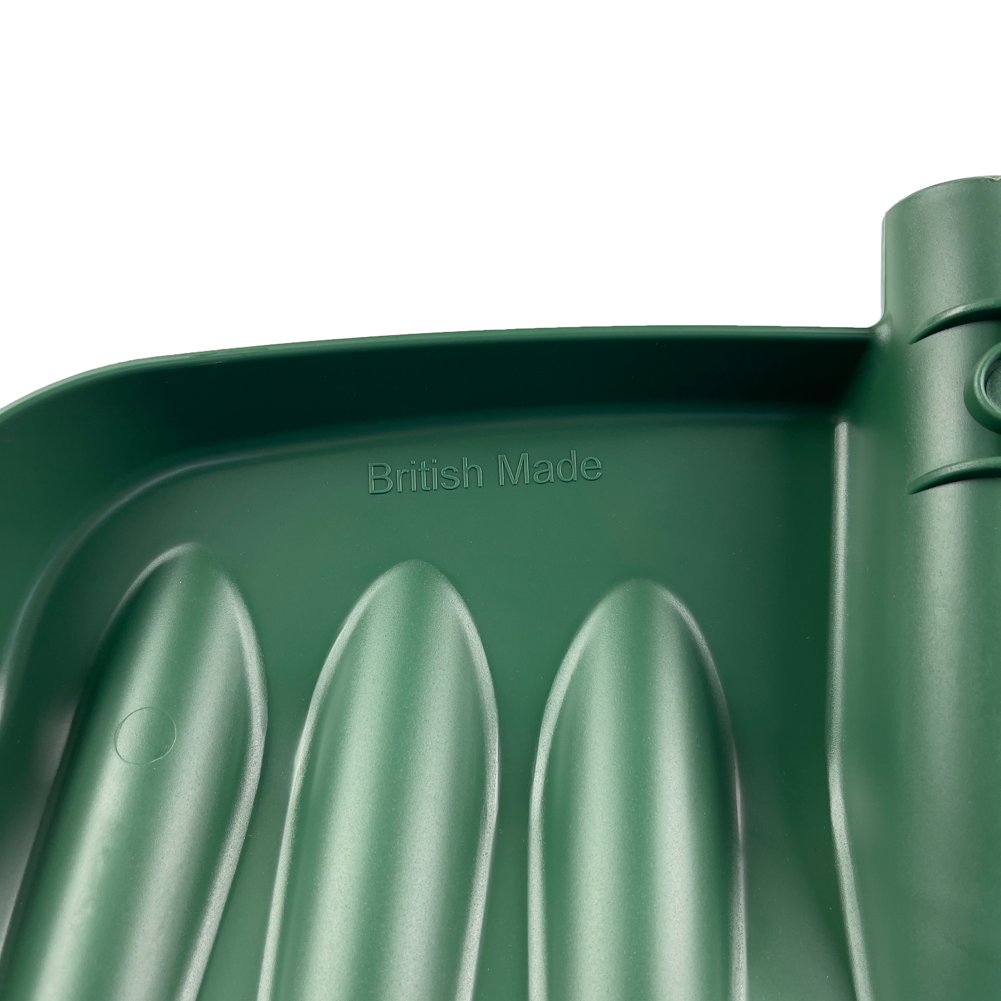 Close-up of the Snow & Garden Shovel Blade Heavy Duty Impact Resistant, made of green plastic with a rounded shape and ribbed texture. The words "British Made" are embossed in the middle. The glossy green surface features a cylindrical section on the right edge, highlighting its durability.