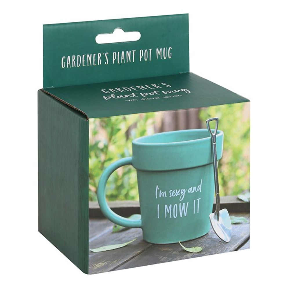 A product box for the Sexy and I Mow It Pot Mug and Shovel Spoon. The green box with white text reads "GARDENER'S PLANT POT MUG." It showcases a ceramic terracotta mug designed to look like a potted plant with the phrase, "I'm sexy and I mow it." A small shovel-shaped teaspoon is attached to the mug.